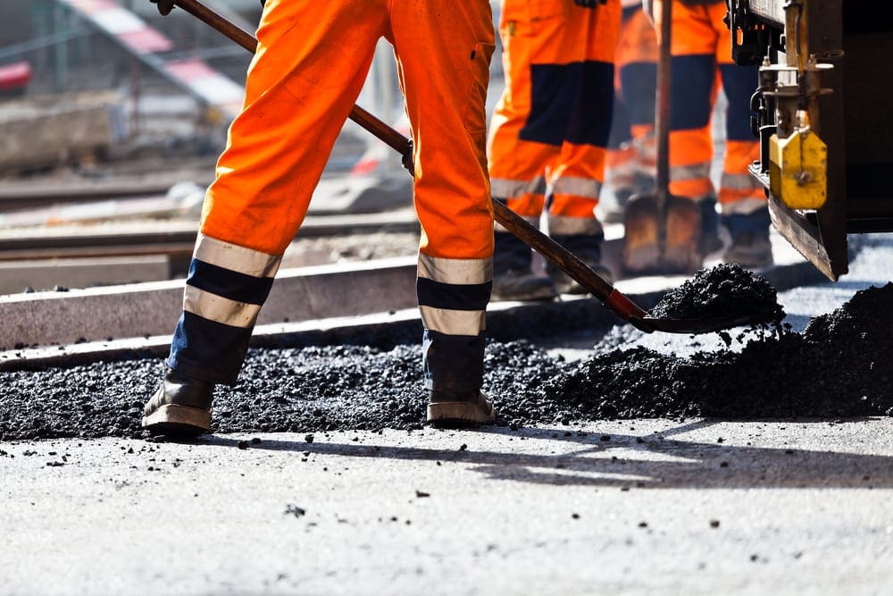 Road construction, worker with shovel