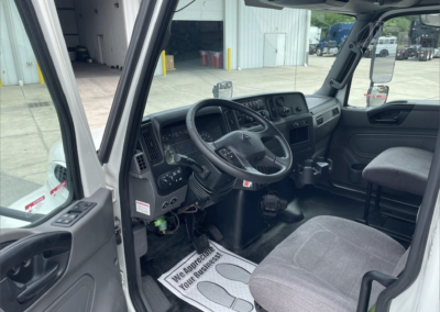 View of driver's side of cab with door open. Steering wheel - 2020 International MV 26-foot box truck available now for $38,500.